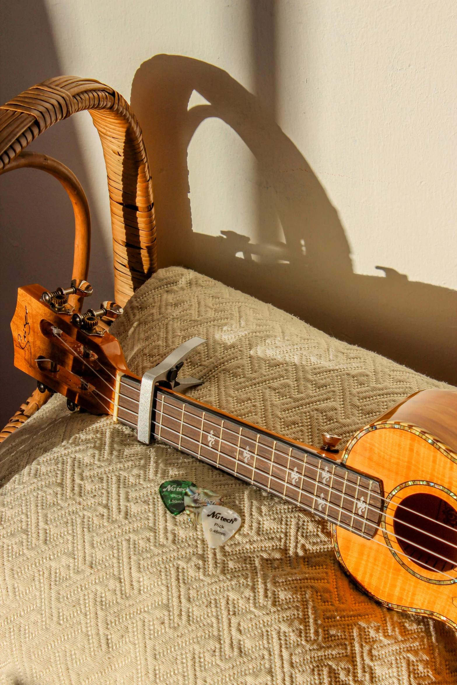 a guitar and a wicker basket laying on the bed
