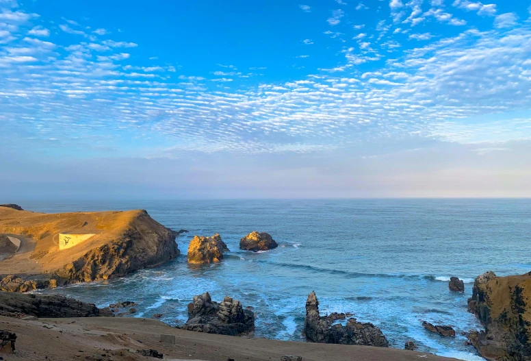 cliffs at the edge of a beach covered in blue water