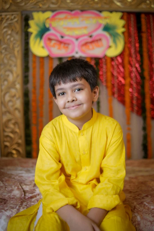 a little boy in a yellow outfit poses for a po