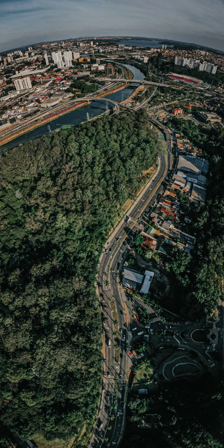 a city is pictured from above, with a long highway