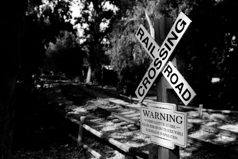 two railroad crossing signs are posted on the pole