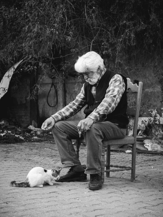 a black and white image of an older man with a kitten