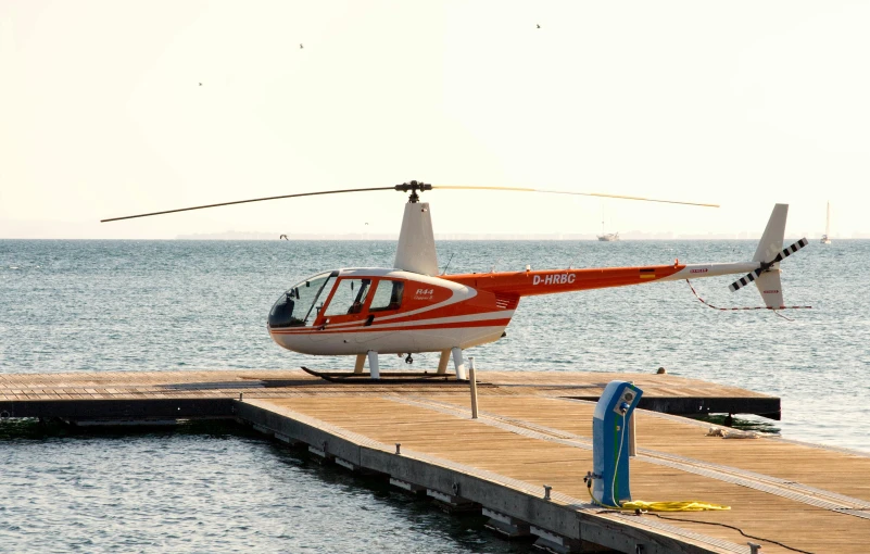 a helicopter is sitting on a dock by the water