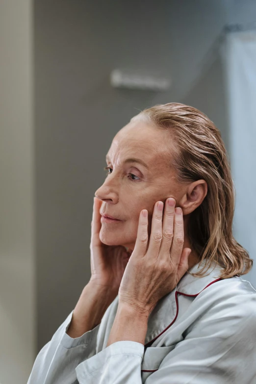 a woman is shown as she holds her hands near her ear