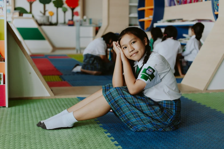 young child sitting on the floor in front of children's art work