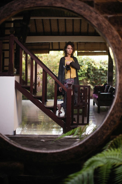 a woman in black jacket standing near a staircase