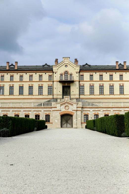 a large brown building that has bushes in front