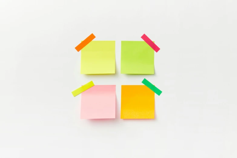 sticky notes with small cut outs of colored sticky notes pinned on them