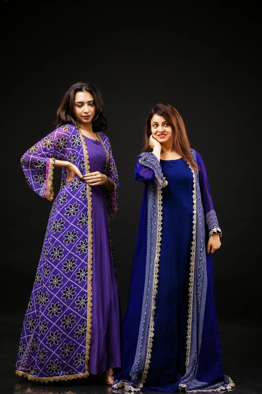 two women pose for a po wearing colorful outfits
