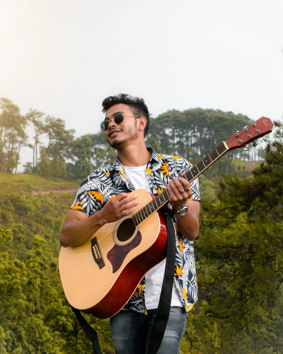 a man in sunglasses holding a guitar by the side of the road