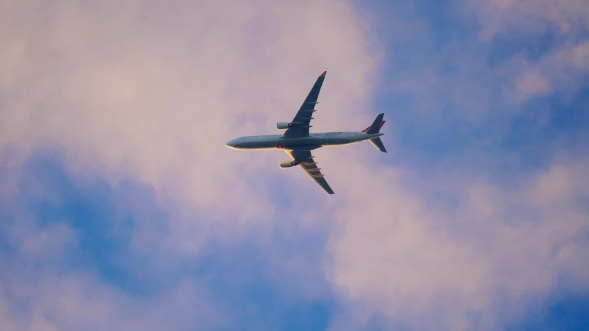 an airplane in the sky with clouds