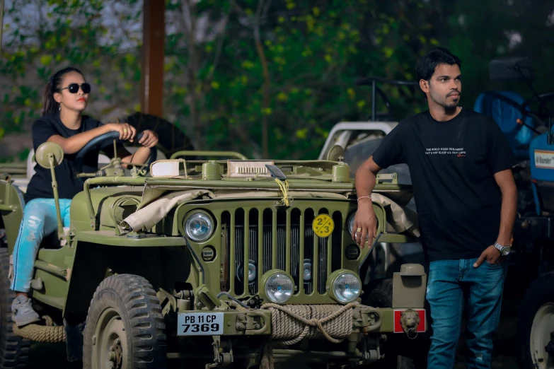 there are two men standing next to an army jeep