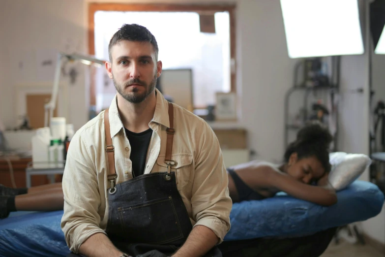 a man holding an apron standing in front of an empty bed