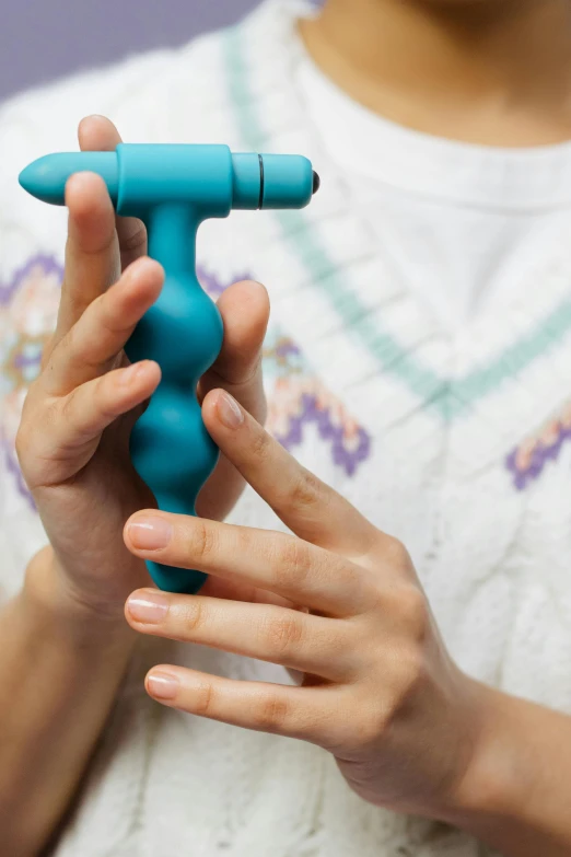 a close up of a person holding a blue toy