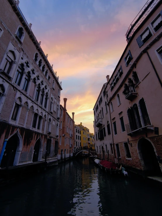 boats ride down a canal in a small city