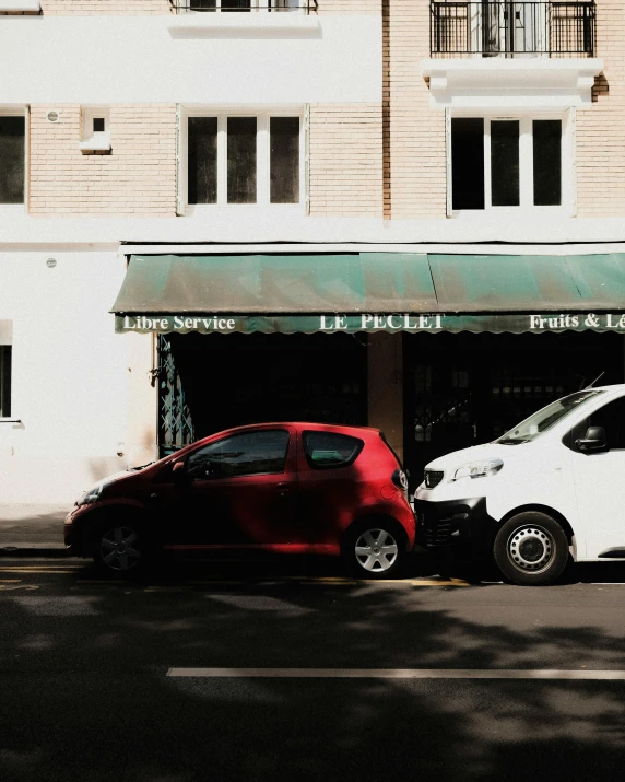 two cars parked in front of a white building