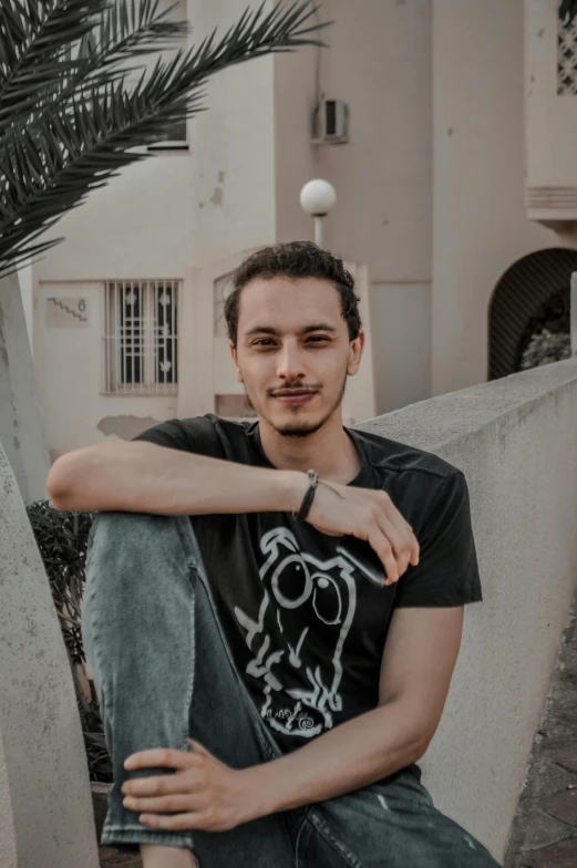 the young man is sitting in front of the building