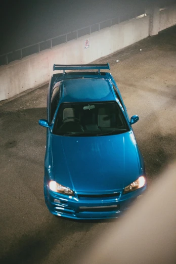 a blue car with a rack parked in an alley