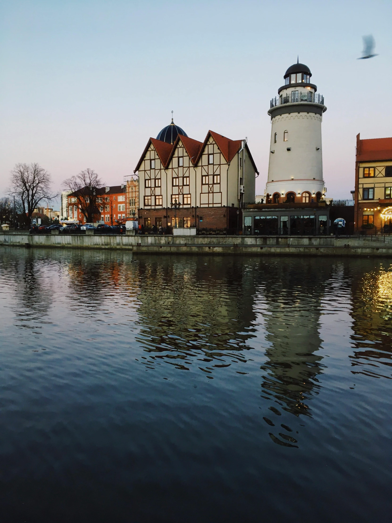 a water way with some houses and a lighthouse