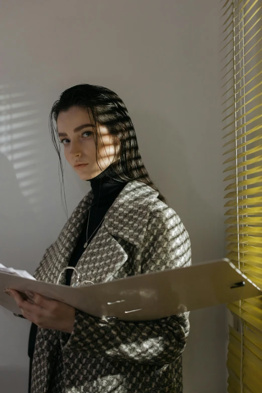 a woman is holding some sheets of paper in her hands