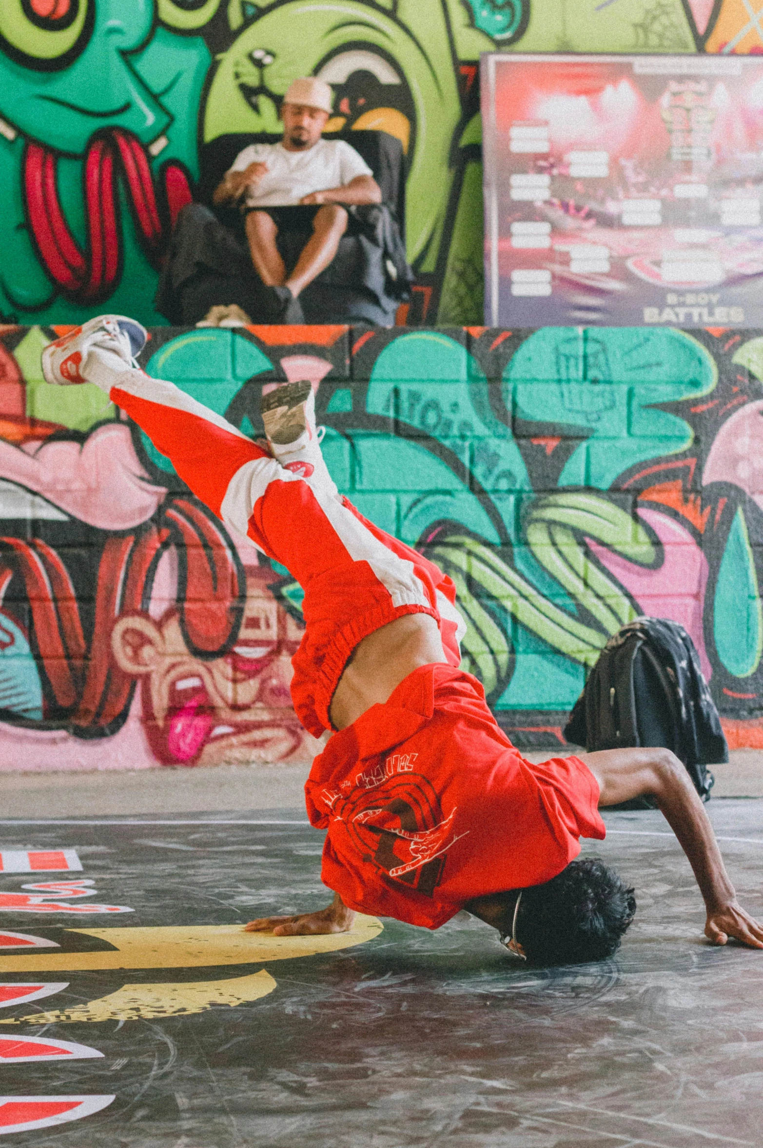 a man in red shorts and white shirt doing a trick on skateboard