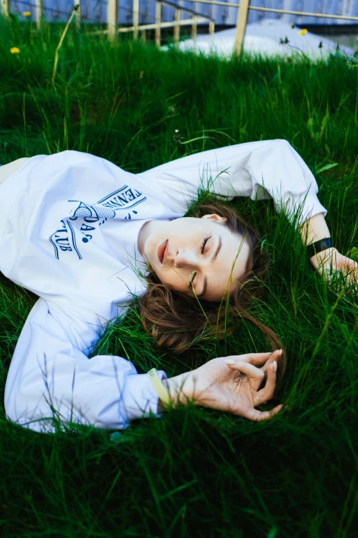 a woman laying in the grass on her stomach