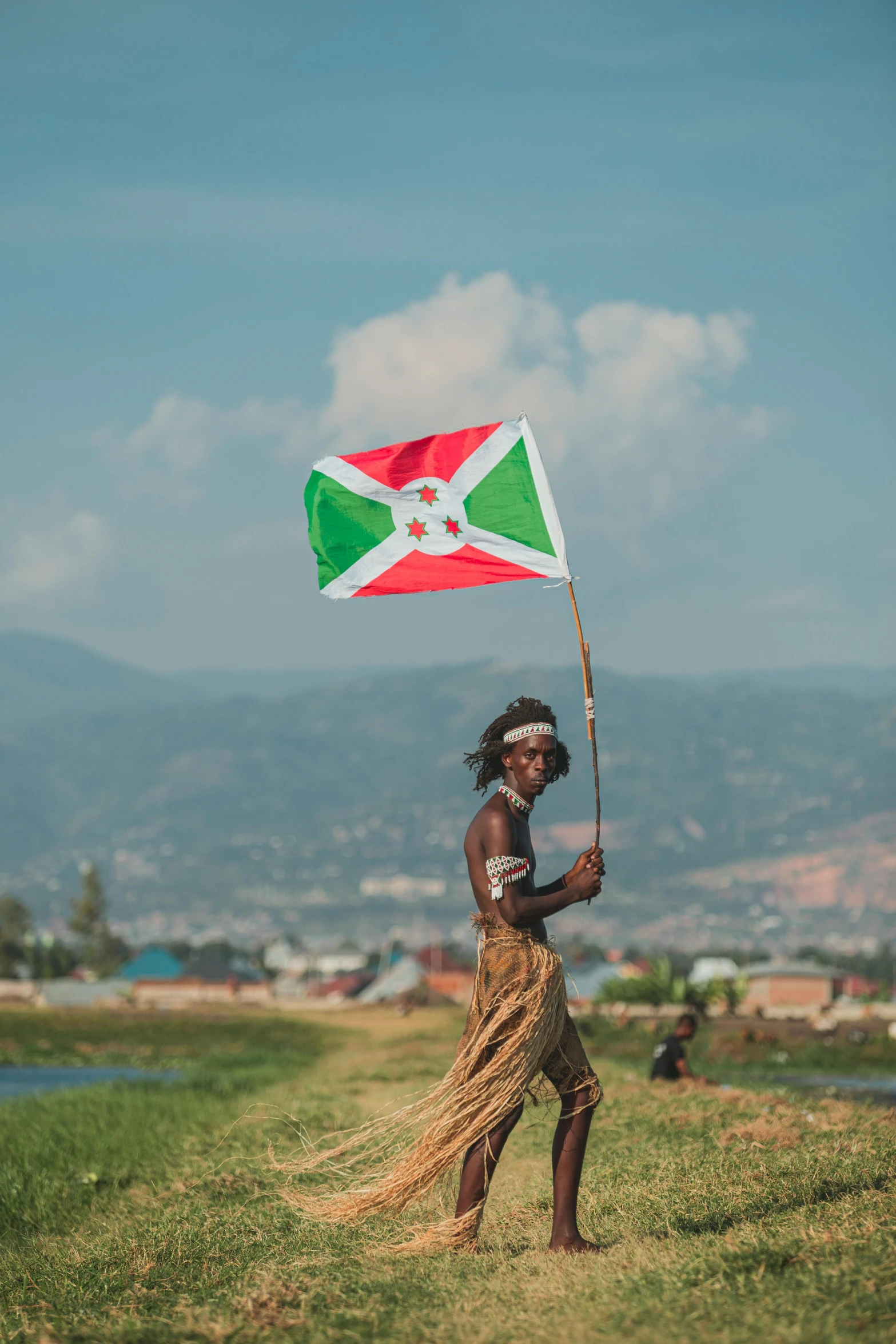 a woman holding a flag while standing in the grass