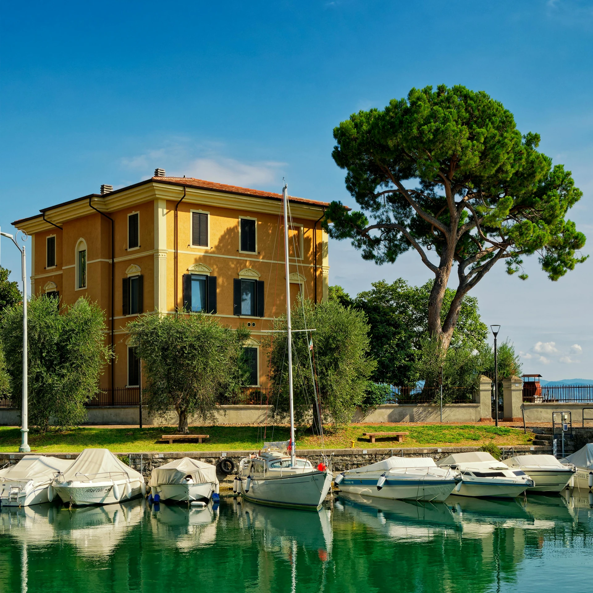 boats are moored in the water near an orange building