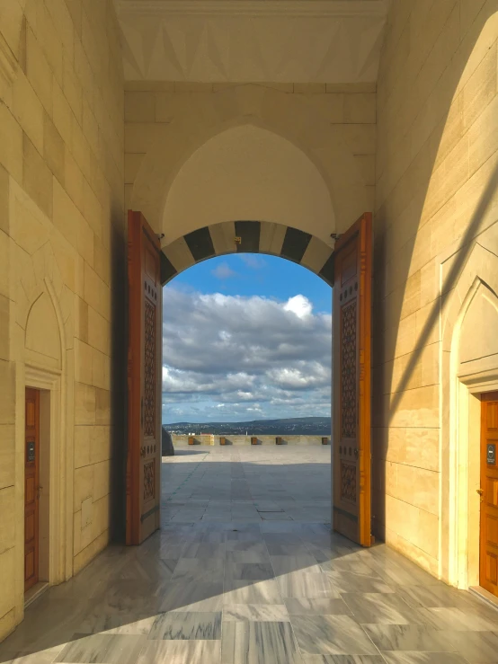 a long walkway is through an archway with light at night