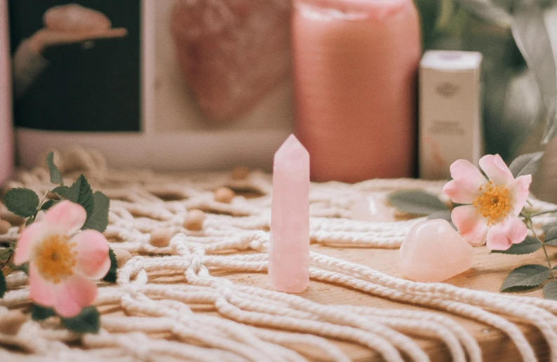 candles and flowers sit on a table with candles in the background