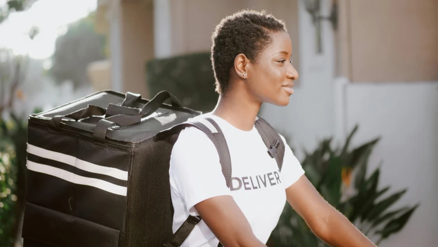 a woman with a backpack that has the words deliver printed on it