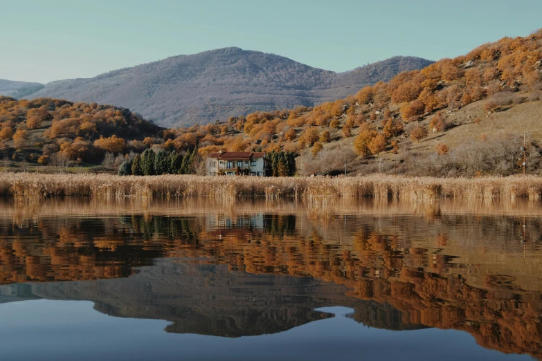 a small cabin is sitting on the edge of a lake