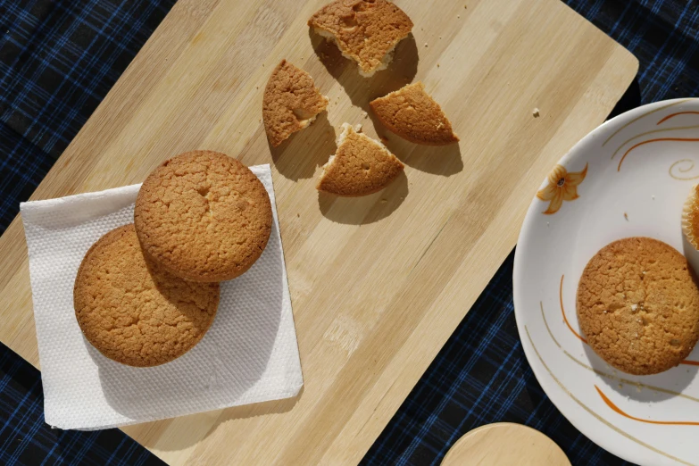 small white plates filled with cookies on a wooden board