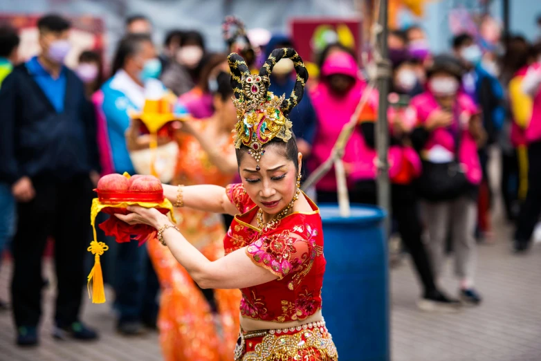 woman in elaborate chinese dance attire posing with a fan