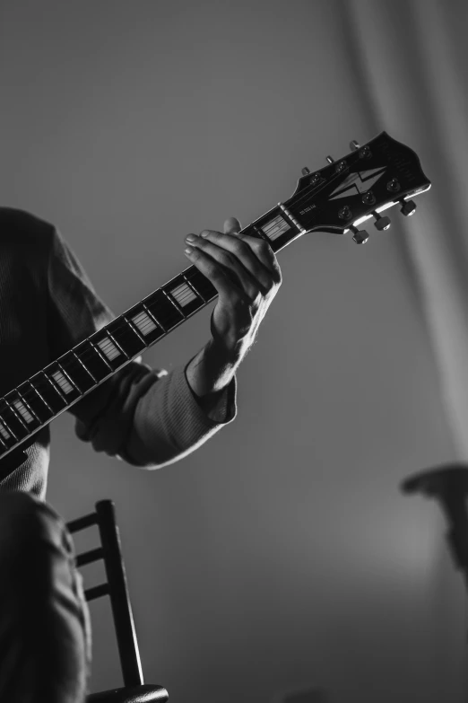 the man is playing his guitar in the room