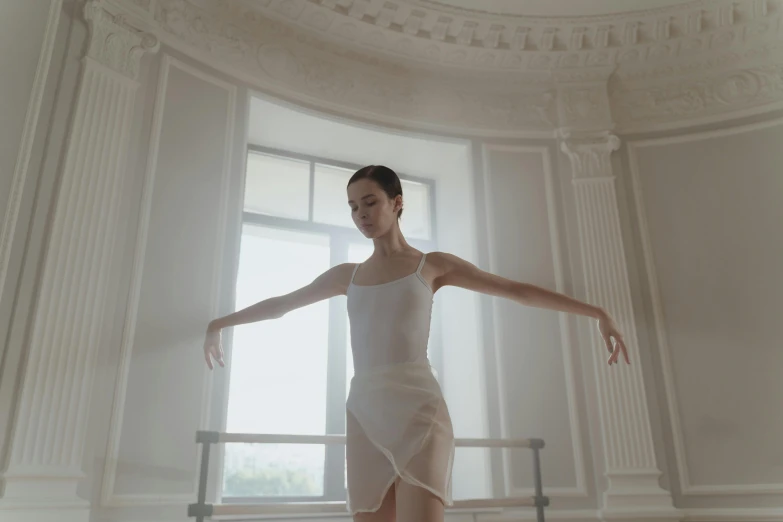 woman posing in front of white wall with open windows