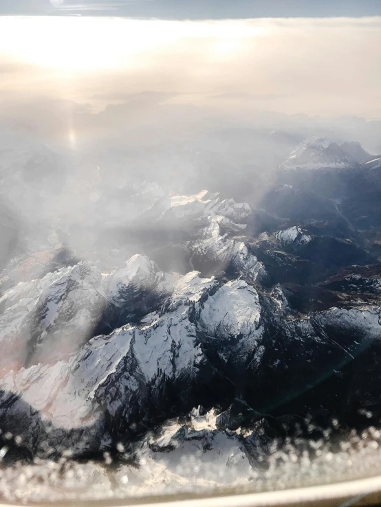 an airplane window showing a mountain landscape on the side