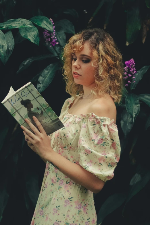 a woman is reading a book outdoors