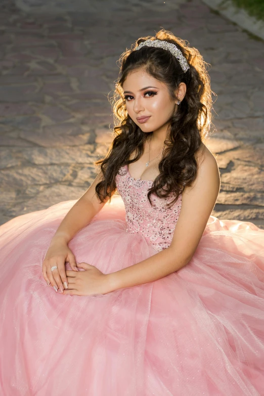 the girl is dressed in a pink dress and posing for the camera