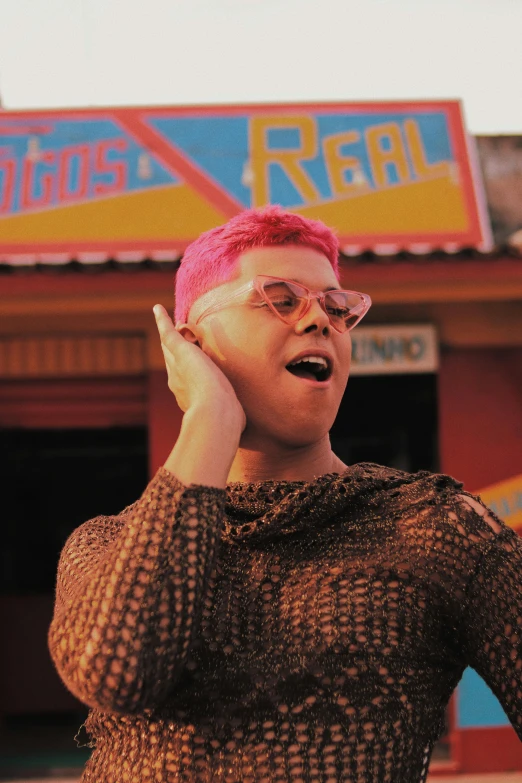 a woman wearing pink hair is standing outside of a business