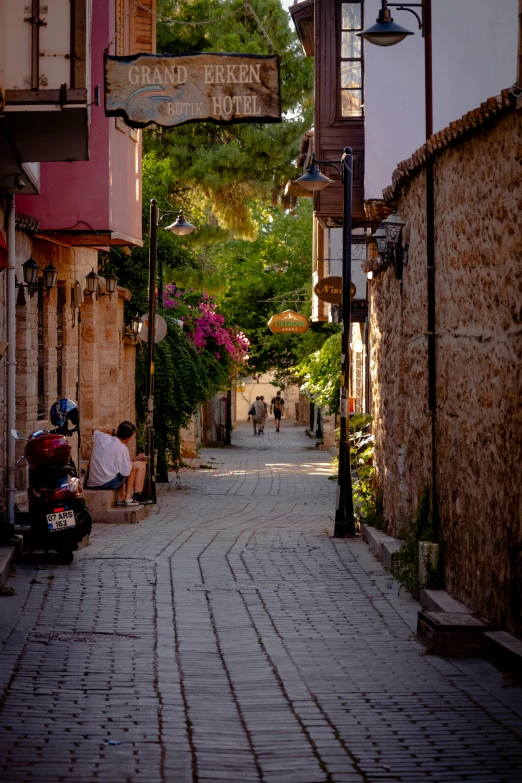 two people sitting on benches between two buildings