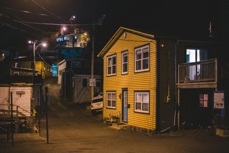 two small yellow buildings are lit up at night