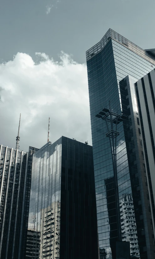 several tall buildings are reflected in glass