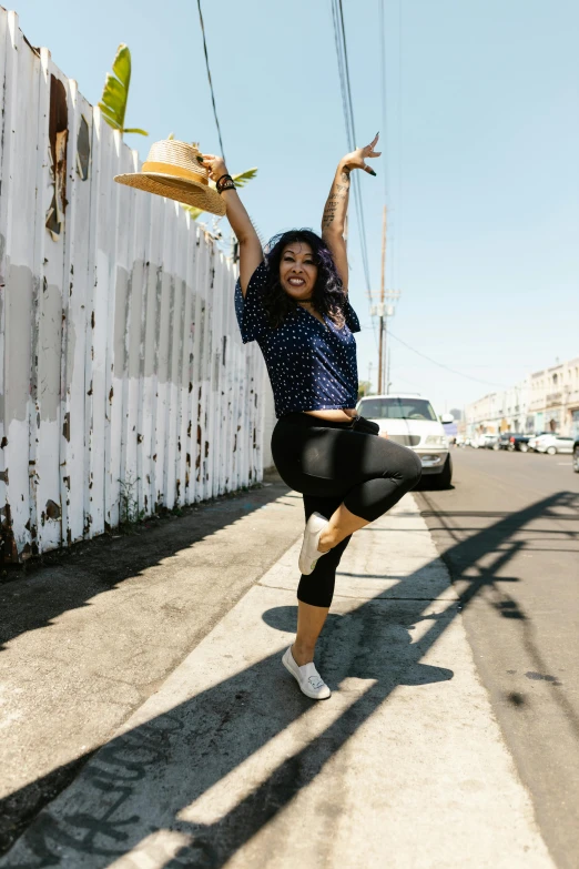 a woman is doing yoga exercises in front of a fence