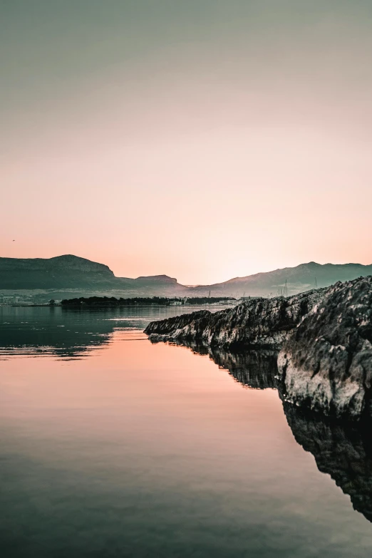 a picture of a person on a hill with water and trees