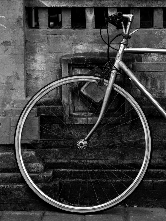 a bicycle leaning on some steps in black and white