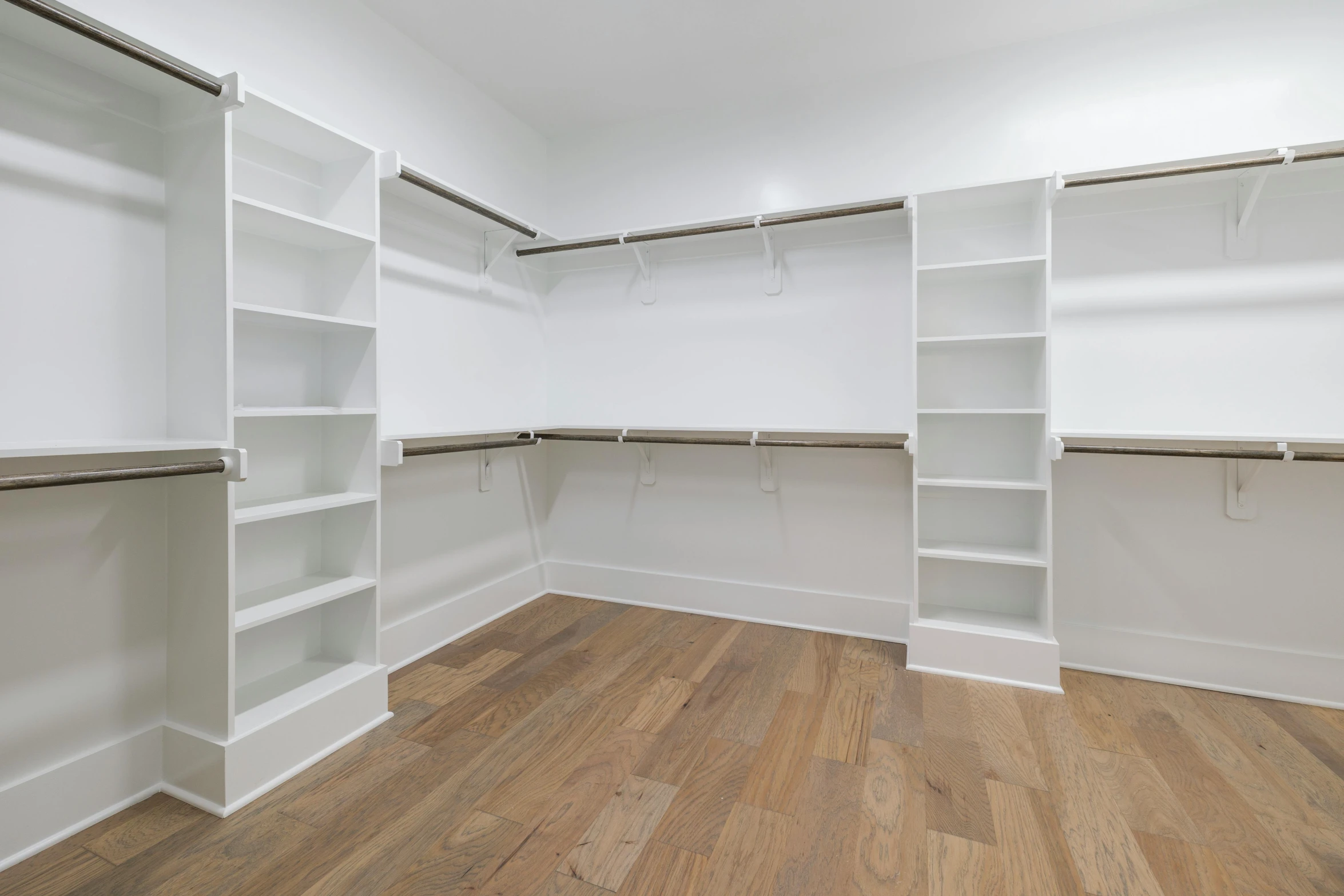 a walk in closet with lots of empty shelves