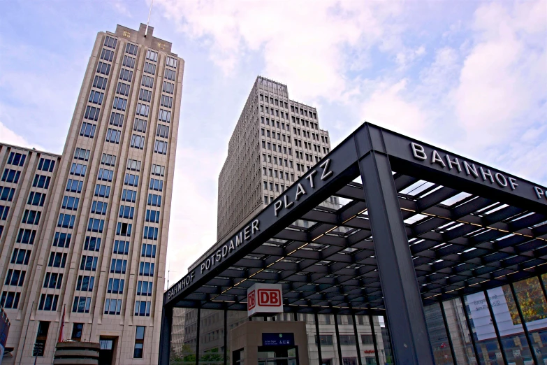 the sign in front of two tall buildings indicates where the shops are