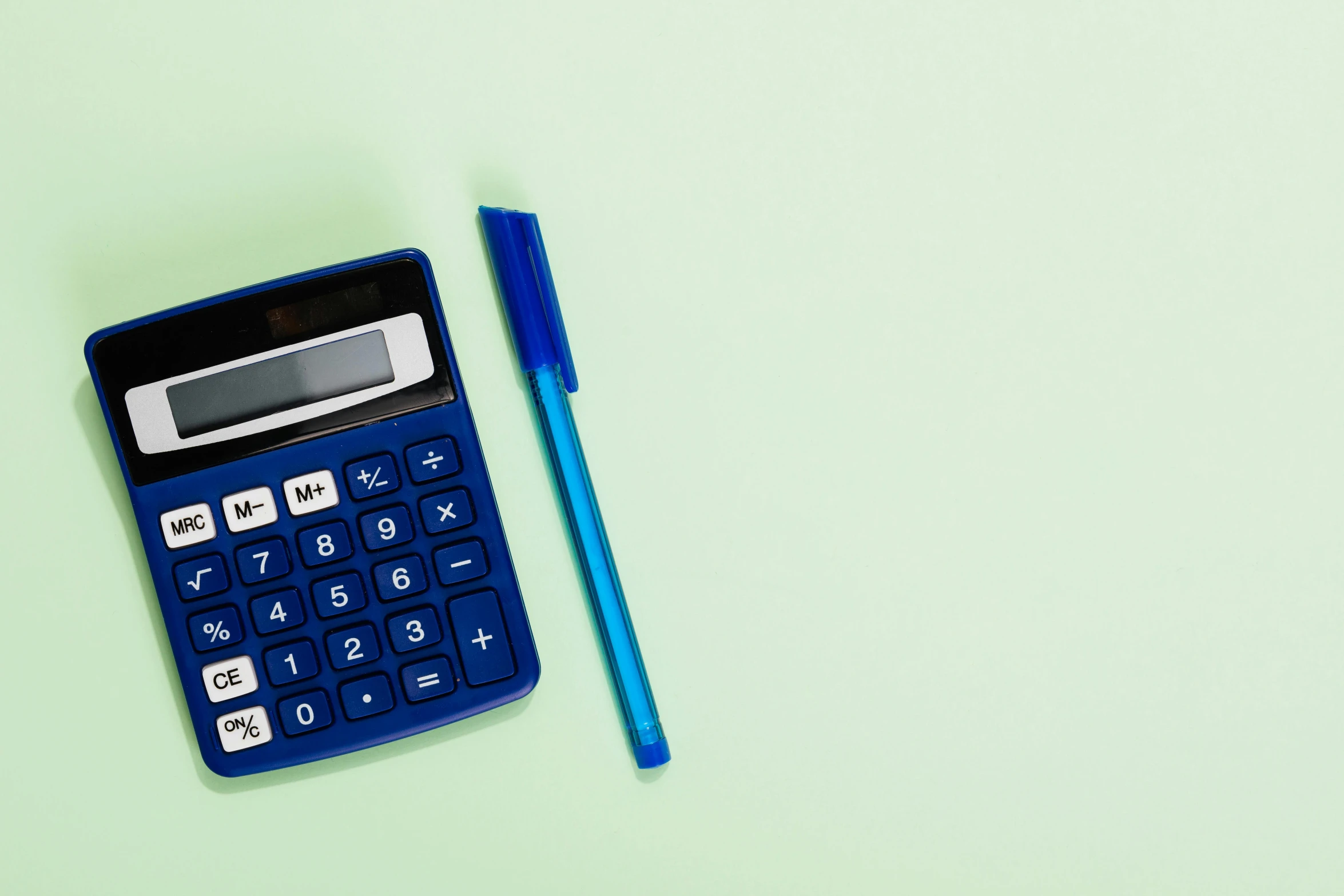 a blue calculator sitting next to a pen