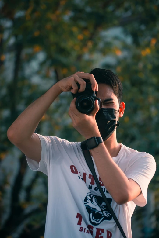 a man standing and holding a camera taking a picture